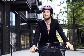 Vrouw op fiets met roze helm